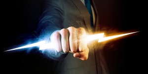 Businessman holding lightning in fist. Power and control