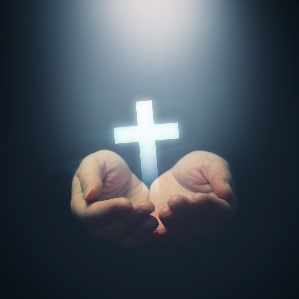 Open hands holding Christianity cross
