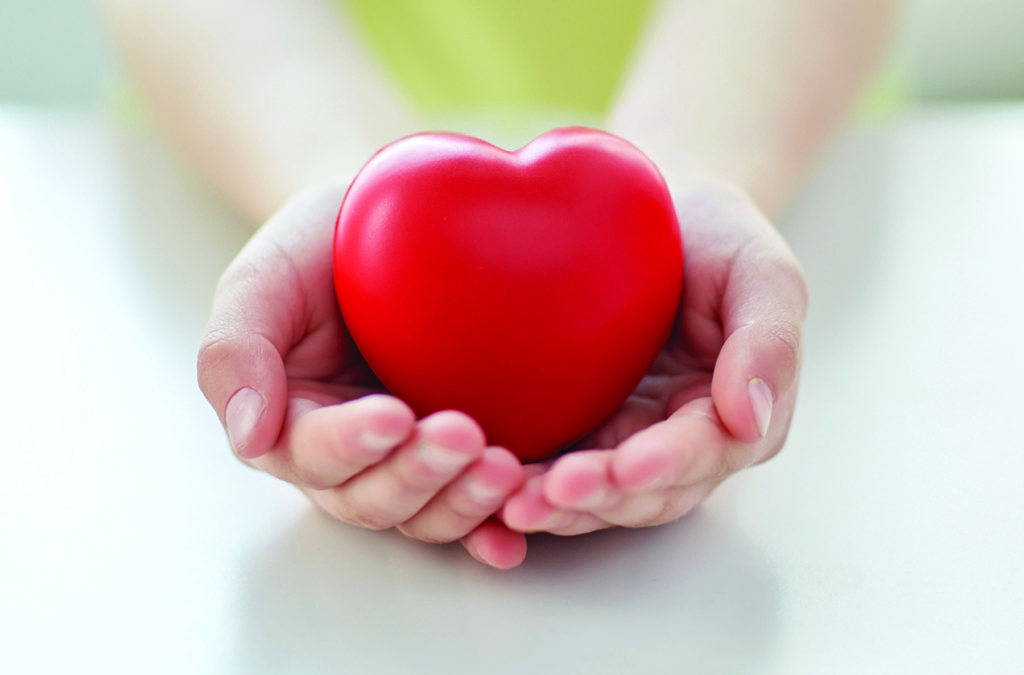 people, love, charity and family concept - close up of child hands holding red heart shape at home