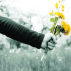 boy gives a girl a bouquet of wild flowers in the apple orchard black and white